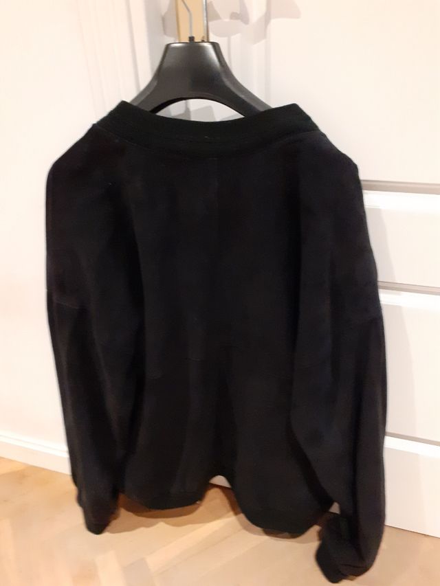 Cazadora hombre ante azul.