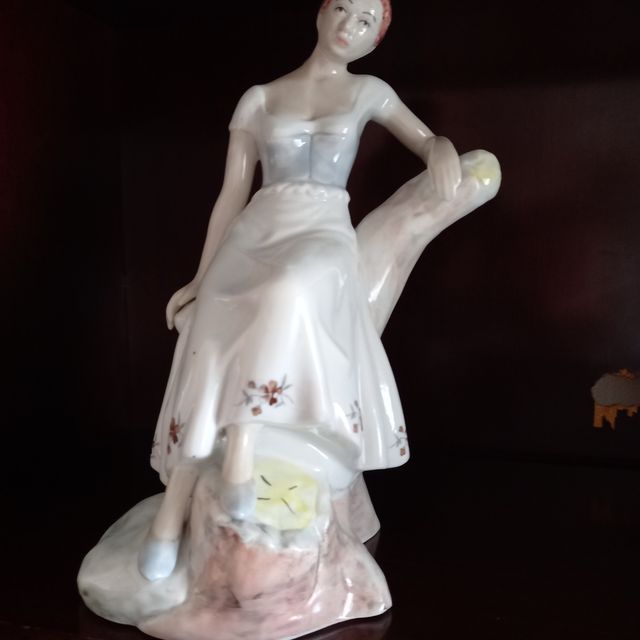 Figura porcelana mujer apoyada en tronco