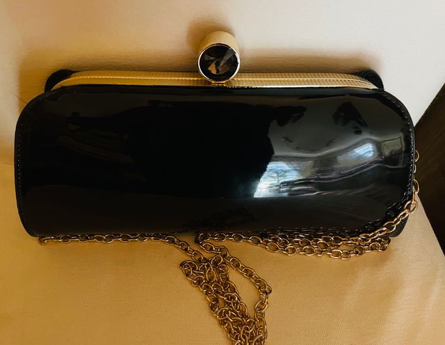 Cartera de mano de charol con cadena dorada