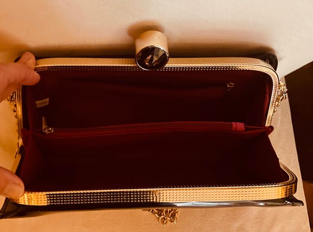 Cartera de mano de charol con cadena dorada