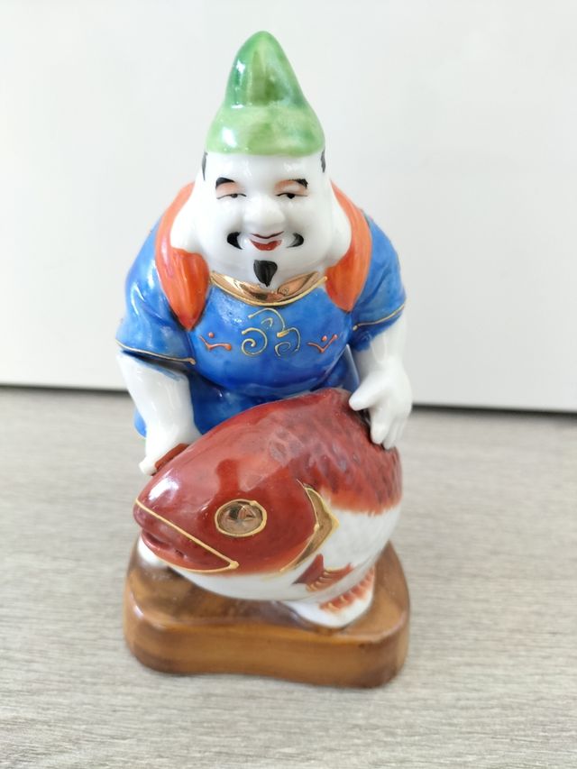 Pescador buda kutani japonés con pez