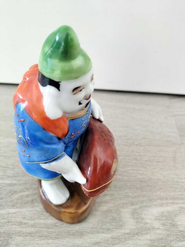 Pescador buda kutani japonés con pez