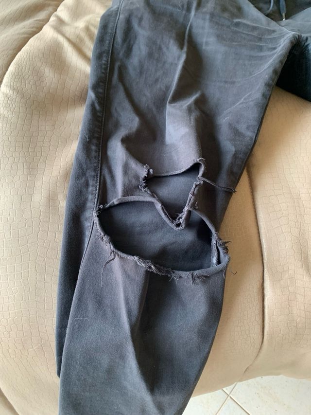 Pantalone nero, con strappo sulle ginocchia