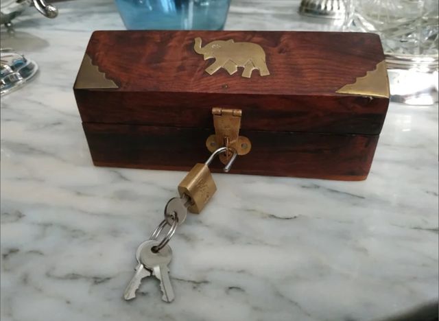 Caja de madera con adornos de metal y candado