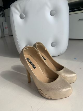 zapatos de tacón dorados con detalle metálico