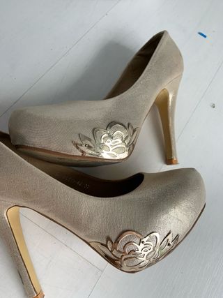 zapatos de tacón dorados con detalle metálico