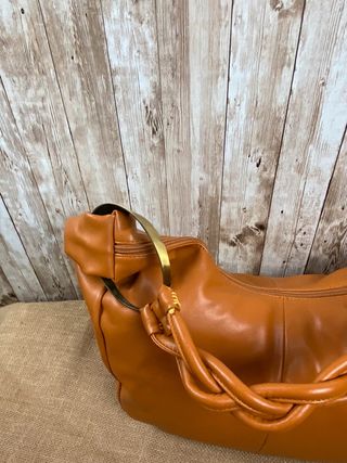 Bolso Hobo marrón claro con apliques dorados. 