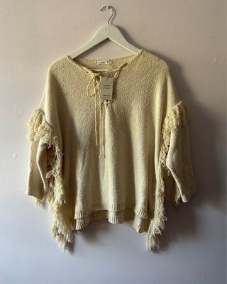 jersey poncho de color crudo con flecos de mango