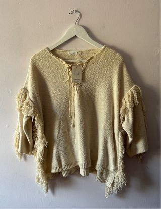 jersey poncho de color crudo con flecos de mango