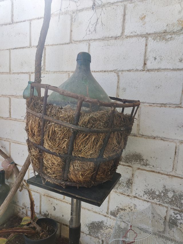 Damajuana antigua con hierro y paja