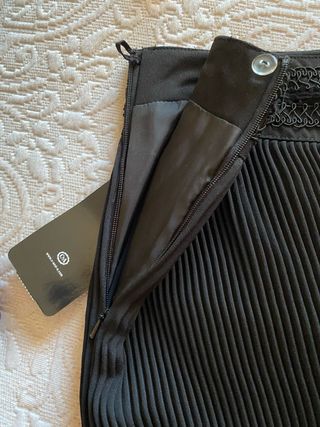 Elegante falda negra plisada, con pasamanería