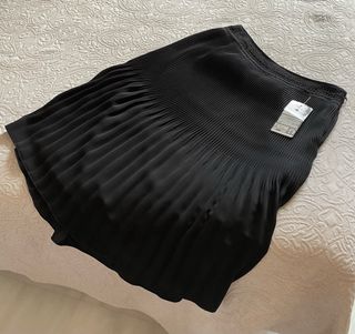 Elegante falda negra plisada, con pasamanería