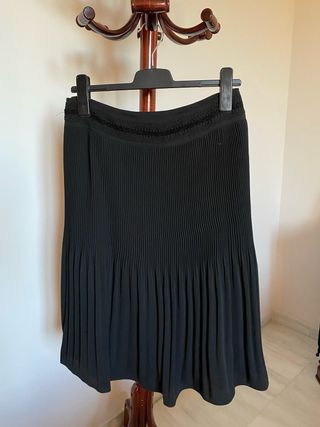 Elegante falda negra plisada, con pasamanería