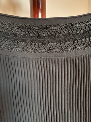 Elegante falda negra plisada, con pasamanería