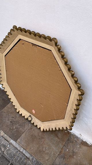 Espejo octagonal tallado en madera.