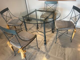 Mesa de cristal con 4 sillas y cojines.