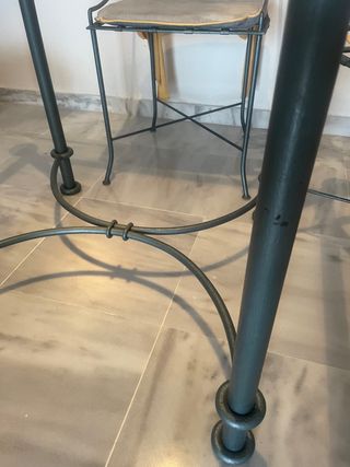 Mesa de cristal con 4 sillas y cojines.