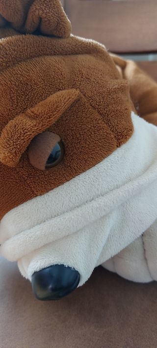 PELUCHE DE PERRO APOYADO EN UN COJÍN