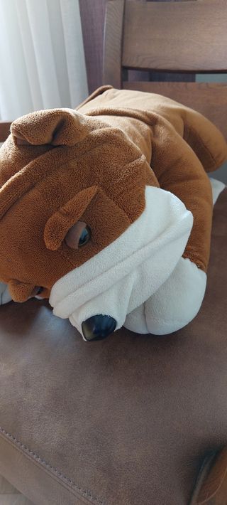 PELUCHE DE PERRO APOYADO EN UN COJÍN