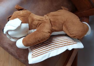 PELUCHE DE PERRO APOYADO EN UN COJÍN