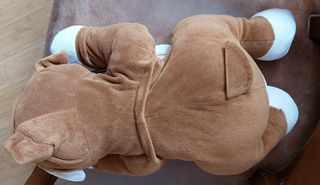 PELUCHE DE PERRO APOYADO EN UN COJÍN