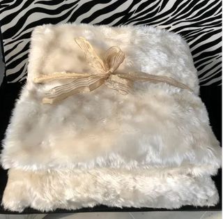 Manta y cojín efecto pelo en blanco