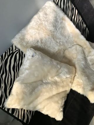 Manta y cojín efecto pelo en blanco