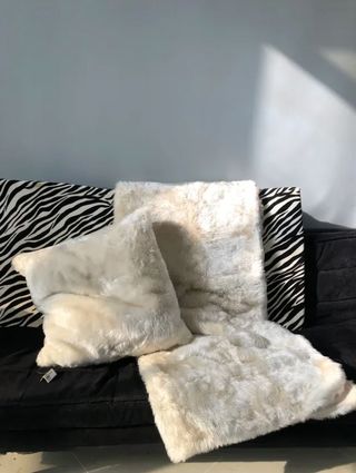 Manta y cojín efecto pelo en blanco