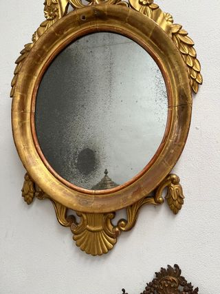 Elegante espejo ovalado dorado en oro fino.