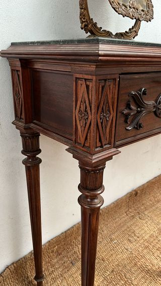 Elegante mesa recibidor con tapa de mármol verde.