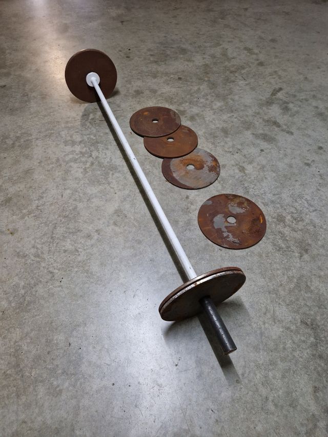 Barra halterofilia casera con discos.