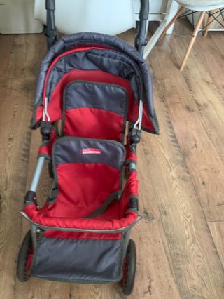 Carrito gemelar rojo para bebés de juguete