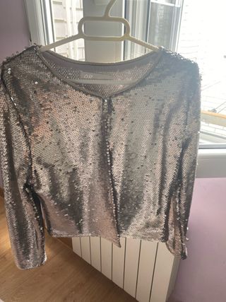 Chaqueta corta de lentejuelas color plateado.