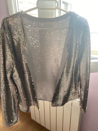 Chaqueta corta de lentejuelas color plateado.