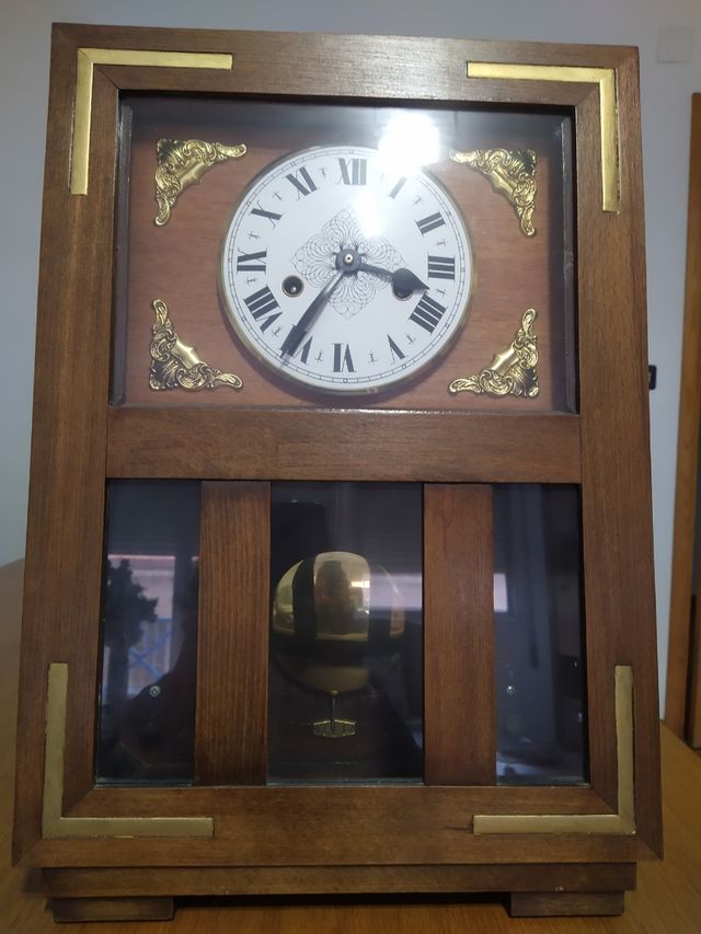 Orologio da parete antico con pendolo.