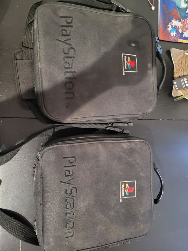 PlayStation 1 i 2 juntas con sus mochilas.