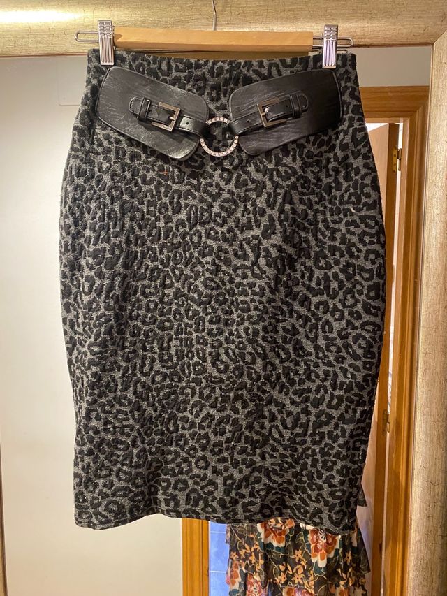 Falda gris y negra con cinturón incorporado.