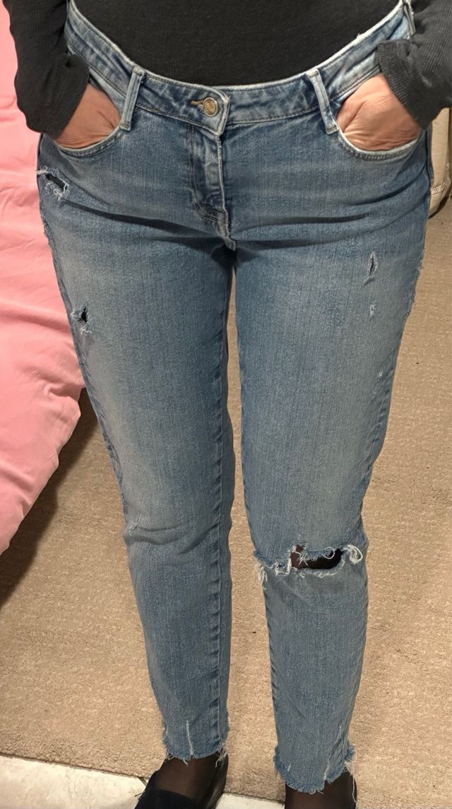 jeans in denim blu con un design distressed