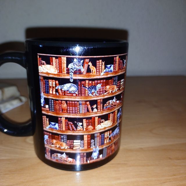 Taza negra y toda alrededor  imágenes de gatos pre