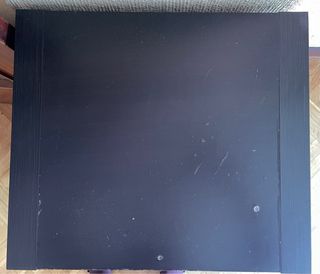 Mueble auxiliar negro con puerta y cajones.