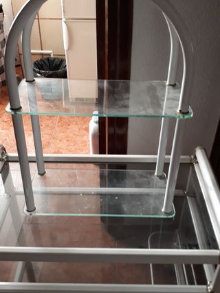 Es una mesa con ruedas y una estantería