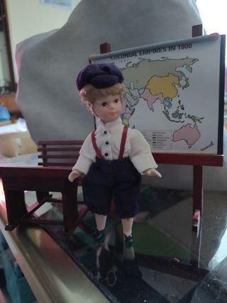 Muñeco porcelana pupitre y mapa mundi