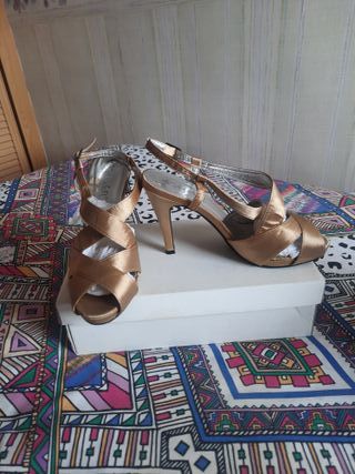 zapatos de tacón dorados con hebilla.
