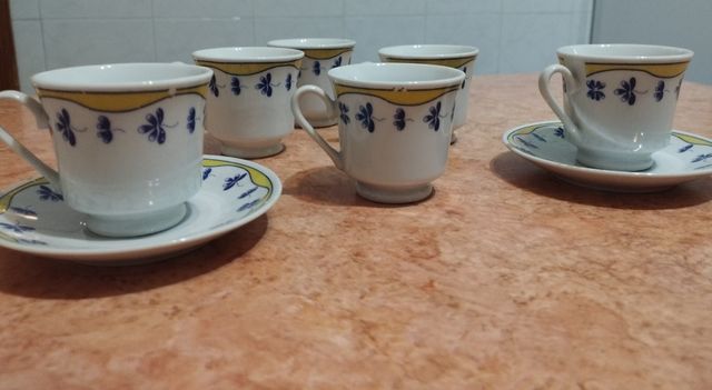 Seis tazas café pequeñas y dos platos.