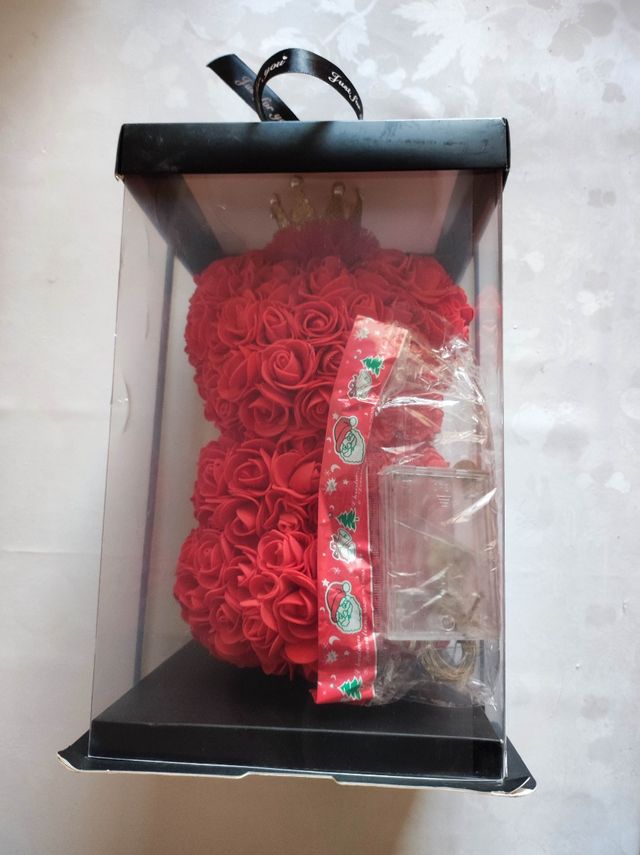 Orso in petali di rose rosse con luci gialle