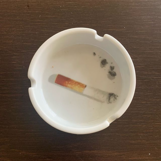 Cenicero blanco, redondo con dibujo. No Fumar