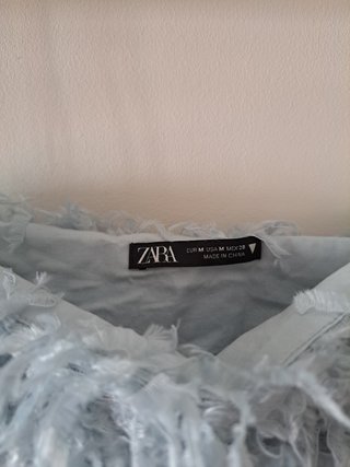 Top azul cielo con plumas