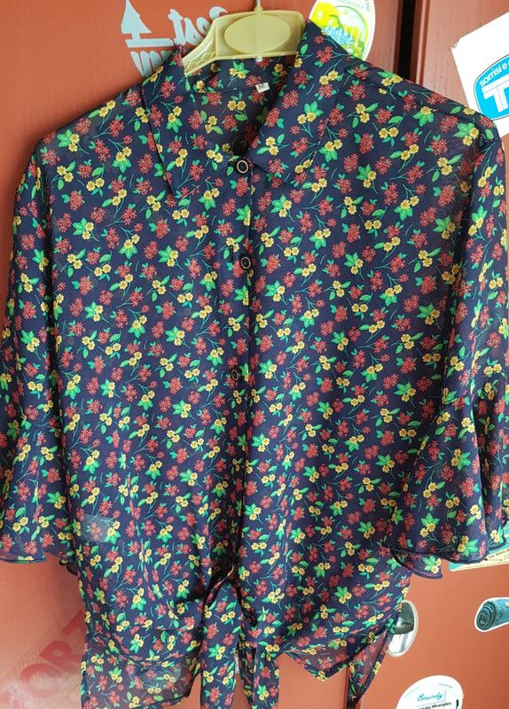 Blusa a motivo floreale semitrasparente.