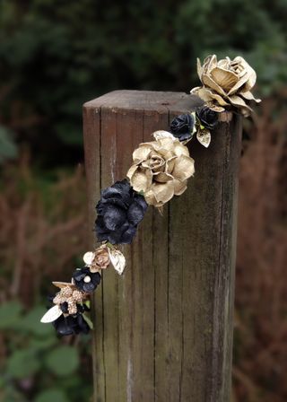 Corona de flores dorada y negra