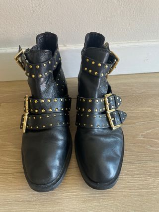 Botines negros con tachuelas doradas.